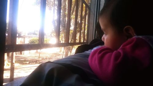 Rear view of boy looking at window