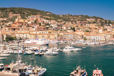 Aerial view of townscape by harbor against clear sky