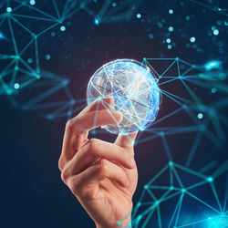 Hand holding illuminated light bulb