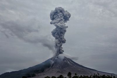 Smoke emitting from volcanic mountain against sky