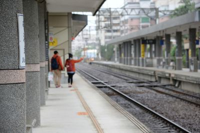 Rear view of people walking on railroad station platform