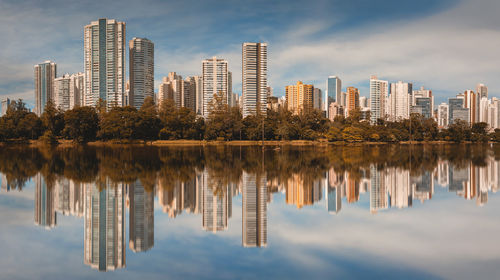 Reflection of buildings in river against sky