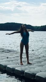 Full length of woman standing by sea against sky