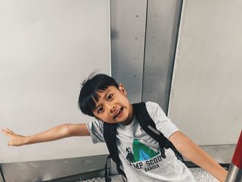 Portrait of cute boy leaning against wall