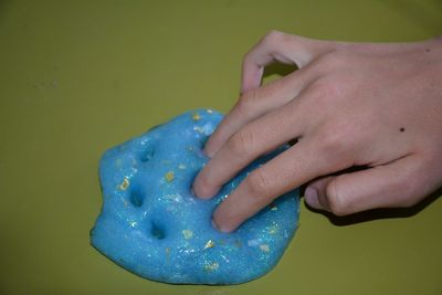 Close-up of hand holding blue paint