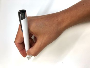 Close-up of woman holding hands over white background