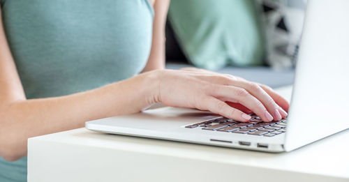 Freelancer working on laptop from home, hands in frame