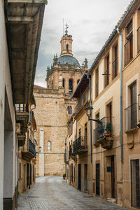 Alley amidst buildings in city against sky