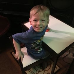 Portrait of smiling boy sitting at home