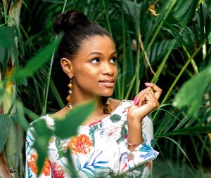 Young woman against plants