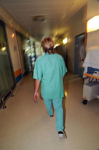 Rear view of woman walking in illuminated building