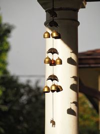 Close-up of wind chime hanging by architectural column