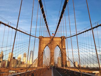 Brooklyn bridge in city against blue sky