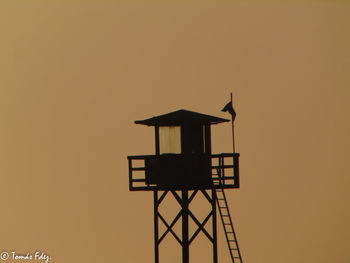 Low angle view of silhouette crane against sky during sunset