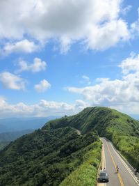 Cars on road by mountain against sky