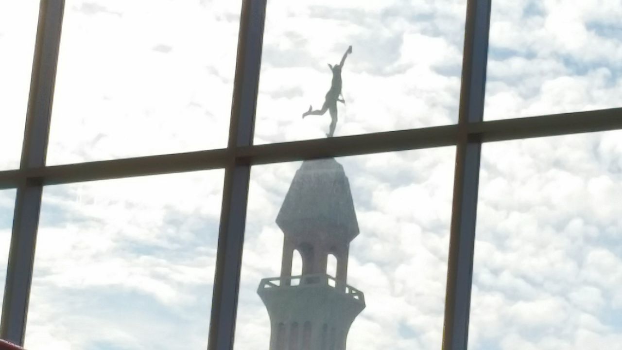 low angle view, sky, animal themes, cloud - sky, human representation, cloudy, bird, sculpture, statue, animals in the wild, wildlife, day, cloud, one animal, animal representation, art and craft, window, perching, two animals