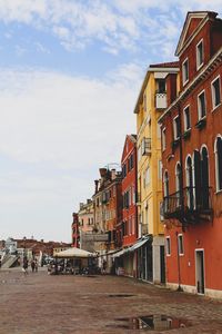 Houses by street in town against sky