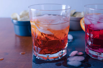 Two spritz with some chips on the table ready for the aperitif, the orangeone is mixed with aperol.