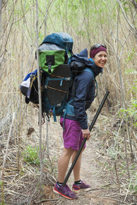 Woman with backpack with packrafting gear on escalante river, utah