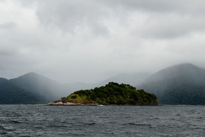 Scenic view of sea and mountains against sky