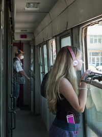 Side view of woman standing in train