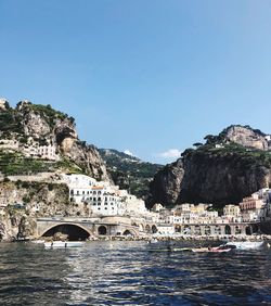 Arch bridge over sea against clear blue sky