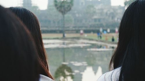 Close-up of women standing against lake