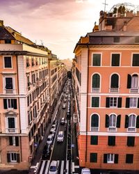 Street amidst buildings against sky during sunset