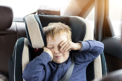 Portrait of cute boy sitting in car