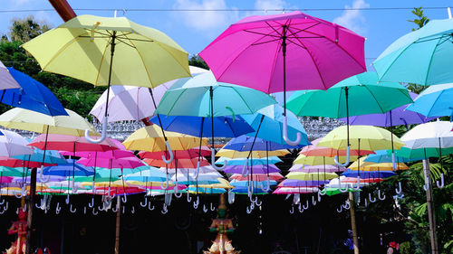 Multi colored umbrellas hanging at market stall in city