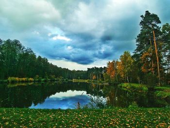 Scenic view of lake by trees against sky