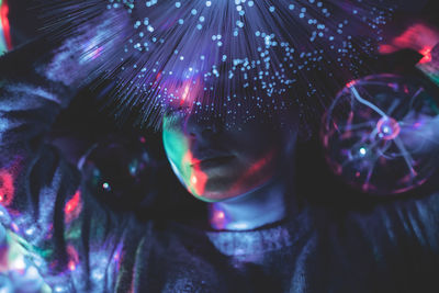 Close-up of woman with illuminated fiber optic in nightclub