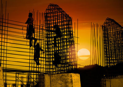 Low angle view of silhouette man against orange sky