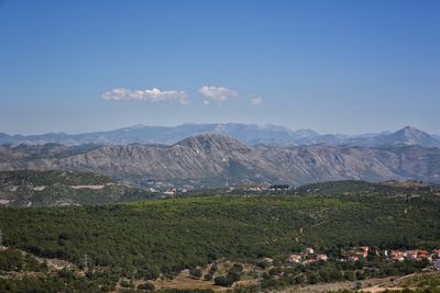 Scenic view of landscape and mountains against blue sky