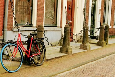 Bicycle leaning on wall of building
