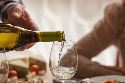 Close-up of hand pouring wine in glass