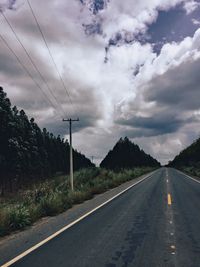 Empty road against cloudy sky