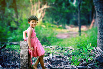 Portrait of smiling girl standing in forest