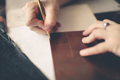 Drawing a sketch on a plate of copper with a metal pen, close-up, materials in a home creative 