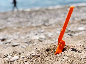 Close-up of orange toy on beach