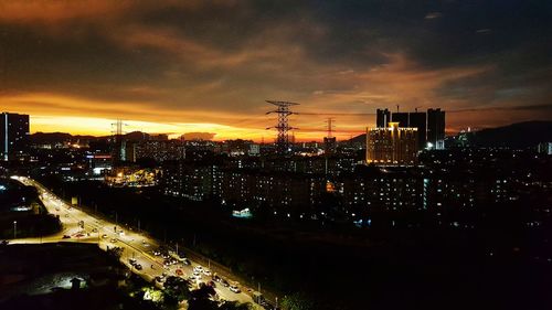 Illuminated cityscape against sky at night