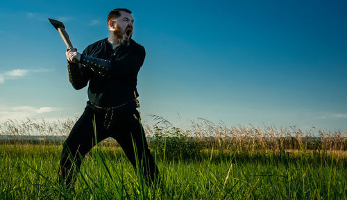 Man standing on field against sky