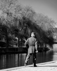 Rear view of man standing by lake