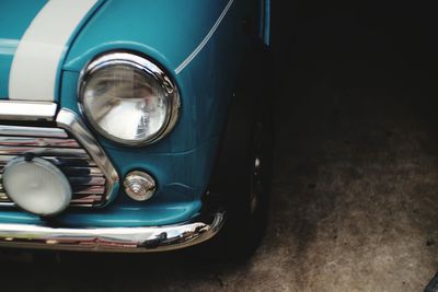 Close-up of vintage car headlight and chrome bumper