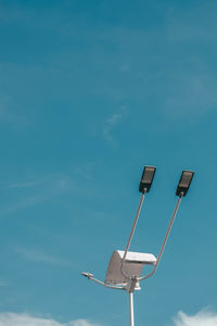 Low angle view of floodlight against blue sky