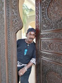 Portrait of man standing against door