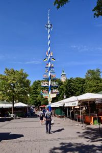 People in city against blue sky