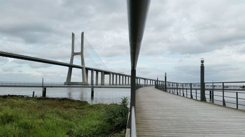 Bridge over river against cloudy sky