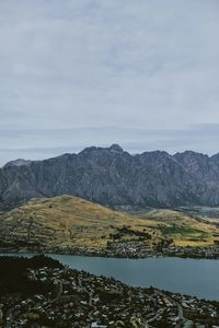 Scenic view of lake by mountain against sky