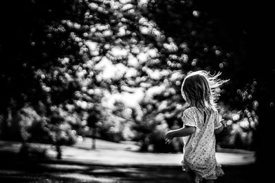 Girl standing against trees